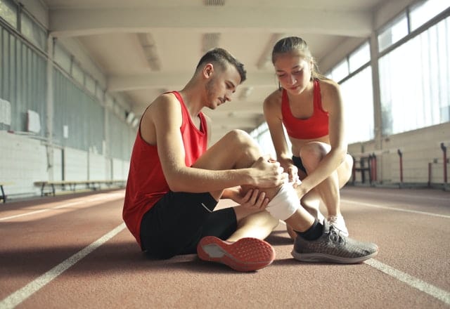 Woman Helping Sportsman With Injury During Cardio Training 3760275